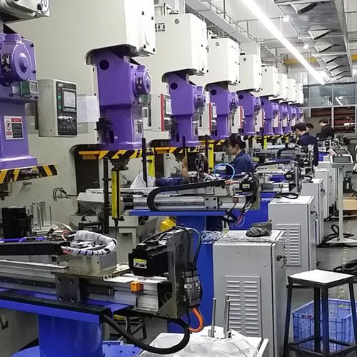 person using crane to move industrial gear box in engineering factory